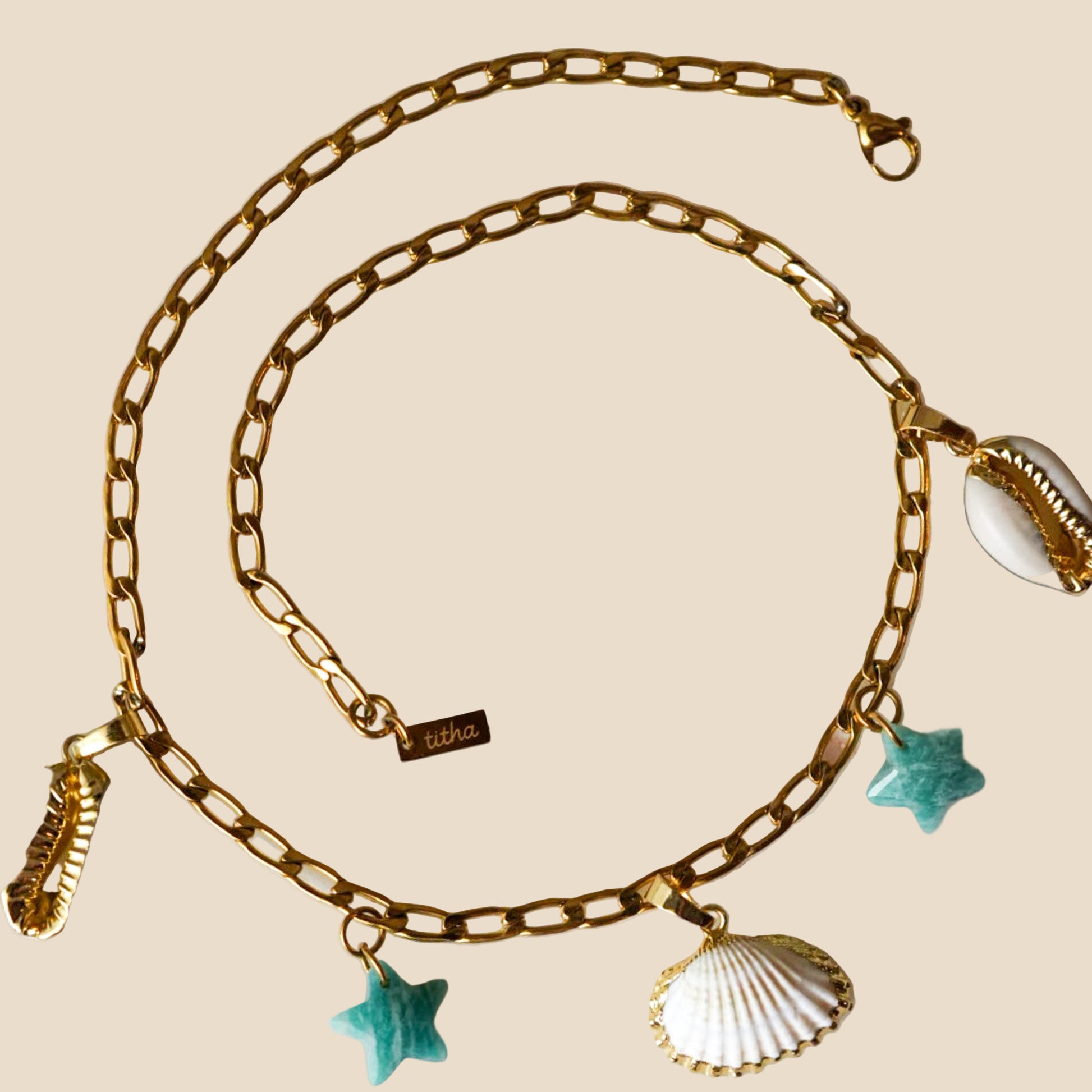 Stainless steel necklace with 18K gold plating, featuring natural shell charms dipped in gold.
