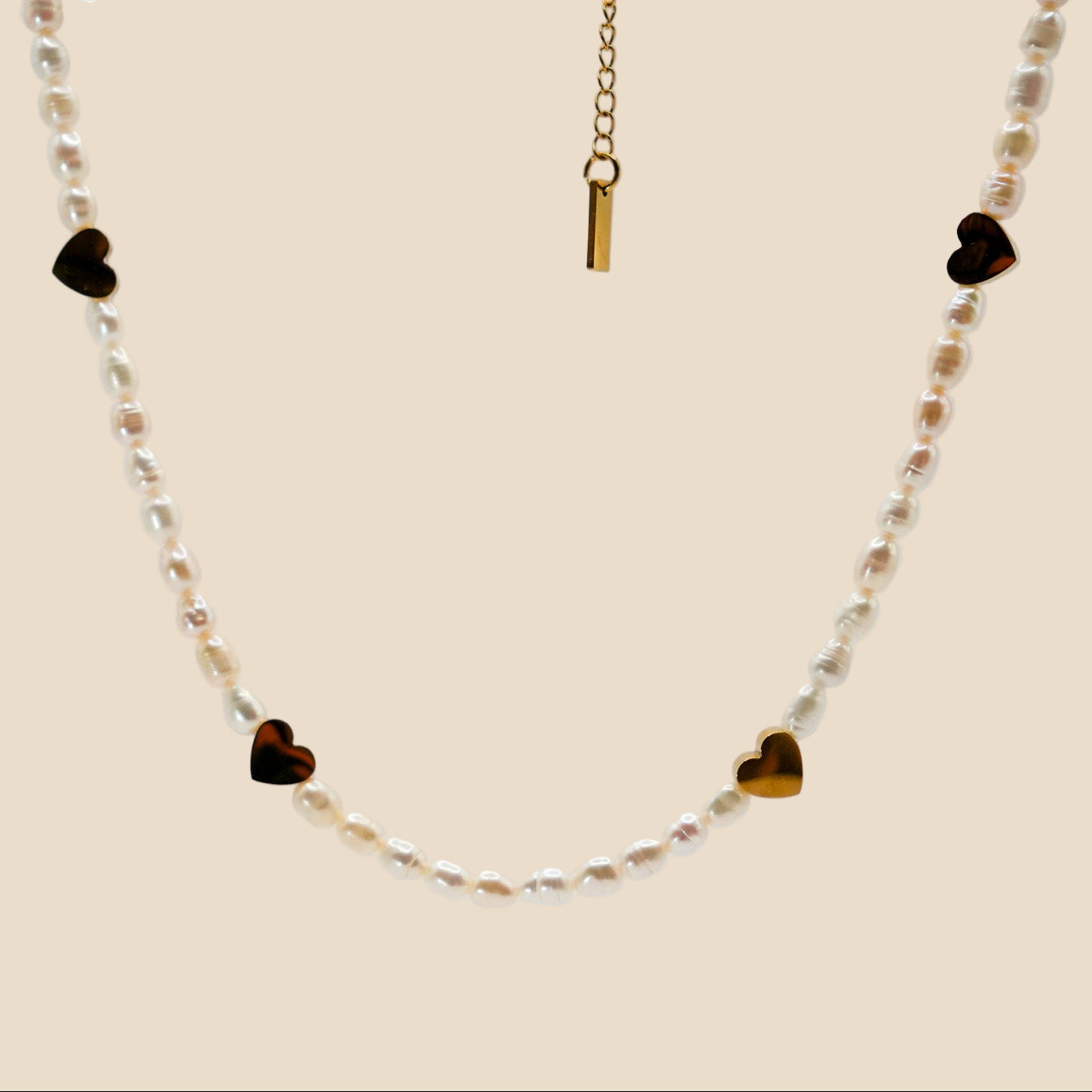 Handmade necklace with natural freshwater pearls and 18K PVD gold-plated stainless steel hearts and accents.